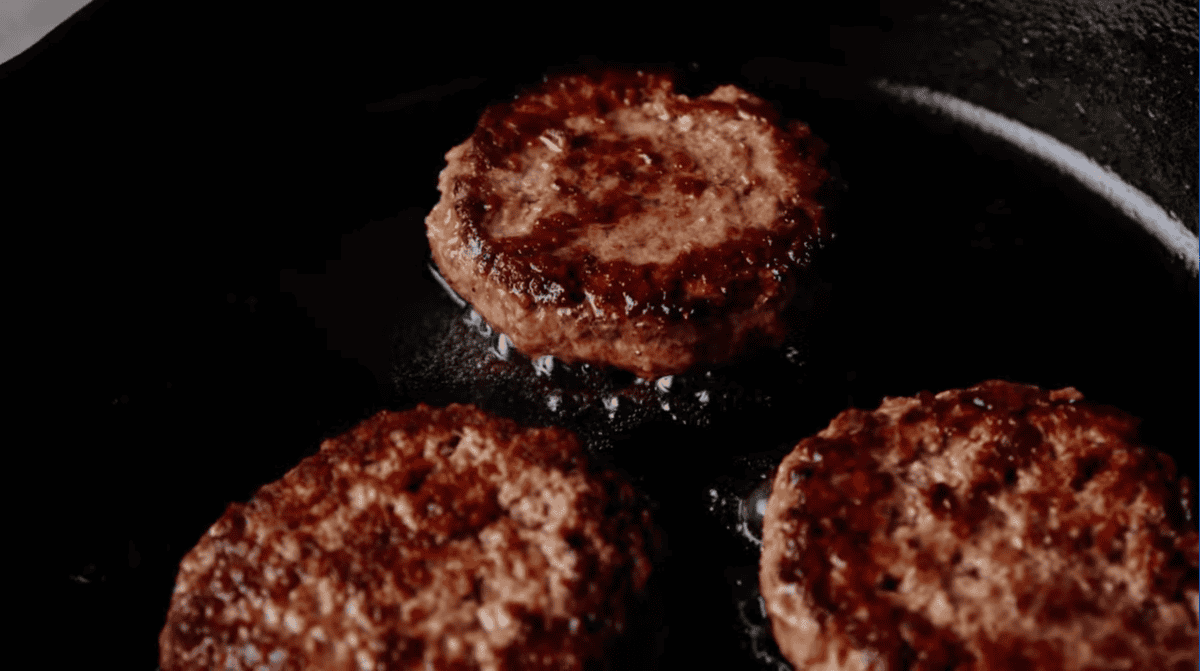 cooking burgers in a skillet.