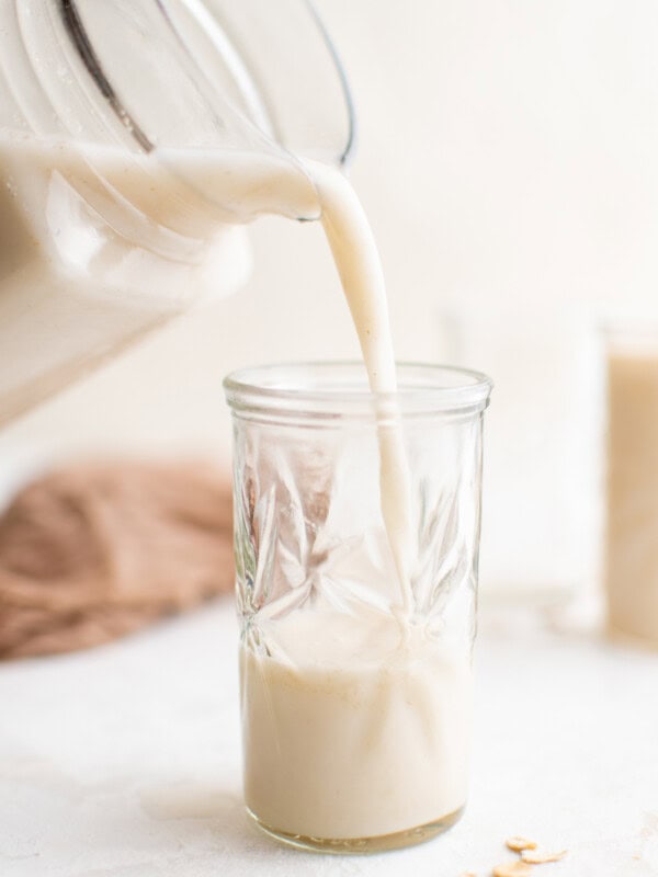 pouring oat milk into a glass