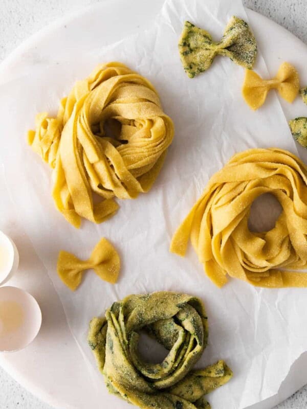 overhead view of 3 nests of homemade pasta on a round marble server.