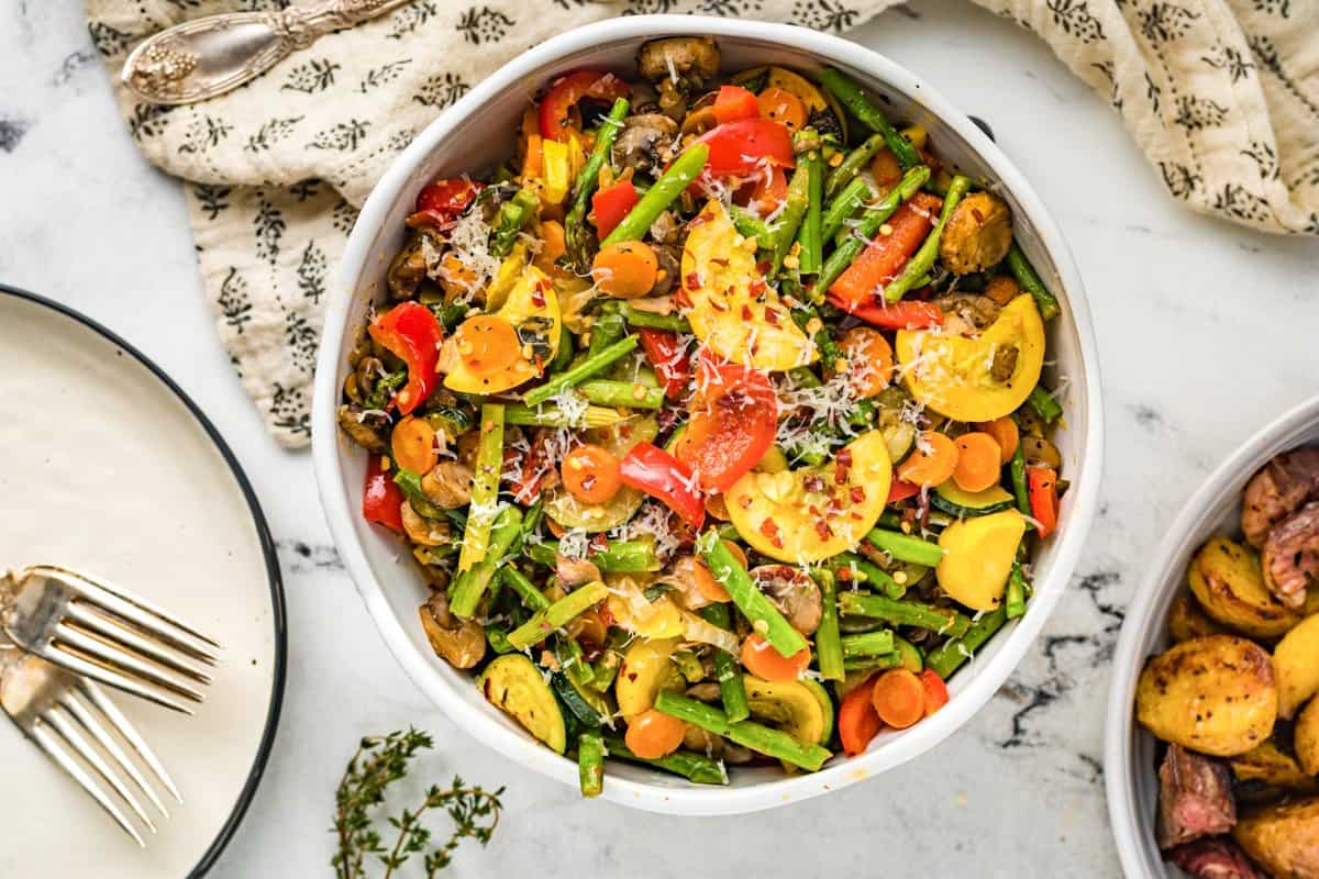 sauteed vegetables in a white serving bowl.