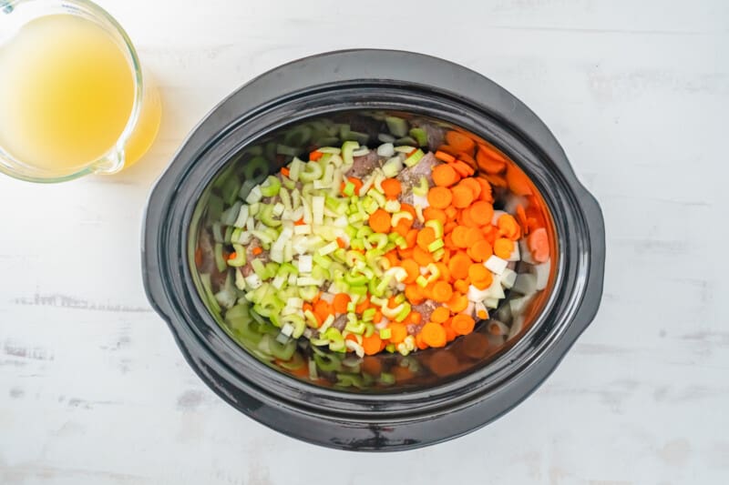 mirepoix on top of chicken in a crockpot.