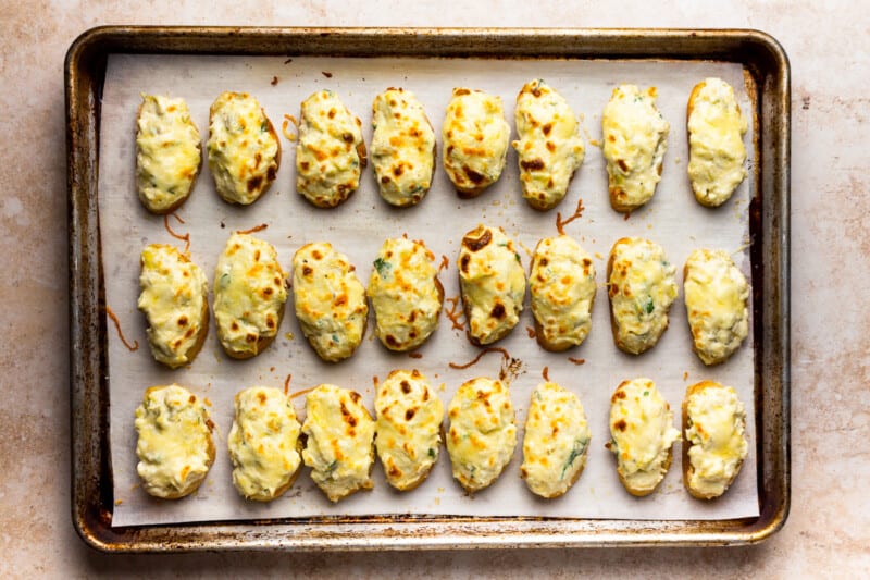 artichoke bruschetta lined up on a baking tray