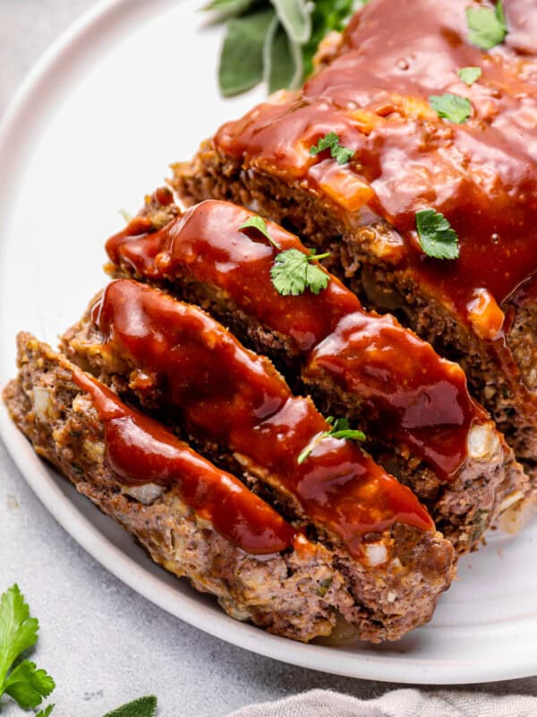 sliced instant pot meatloaf on a white serving plate.