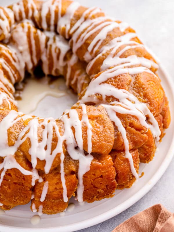 close up of iced easy monkey bread on a white serving plate.