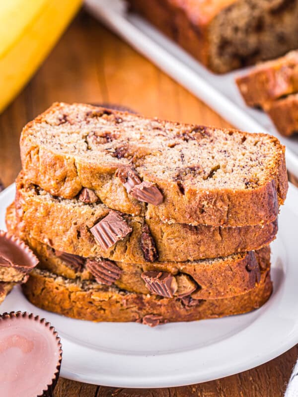 4 slices of reeses peanut butter cup banana bread stacked on a white plate.