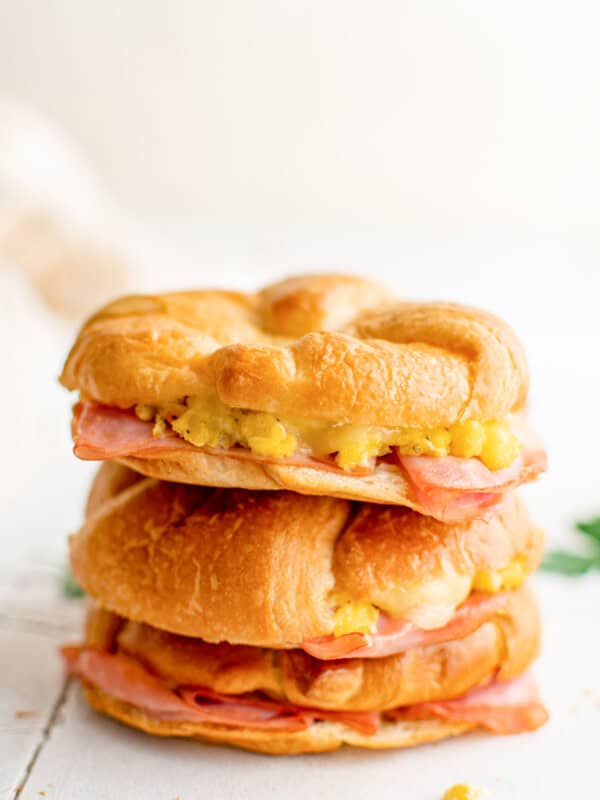 2 stacked croissant breakfast sandwiches on a table.