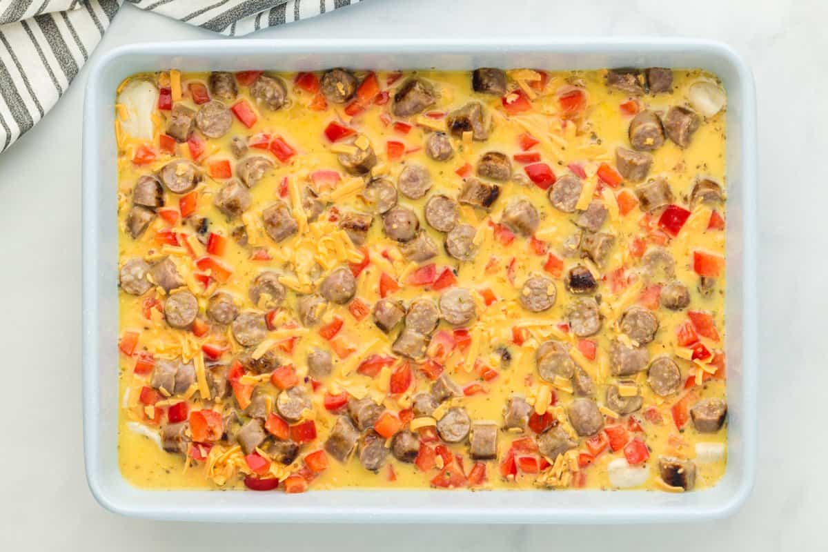 Unbaked egg casserole mixture in a baking dish.