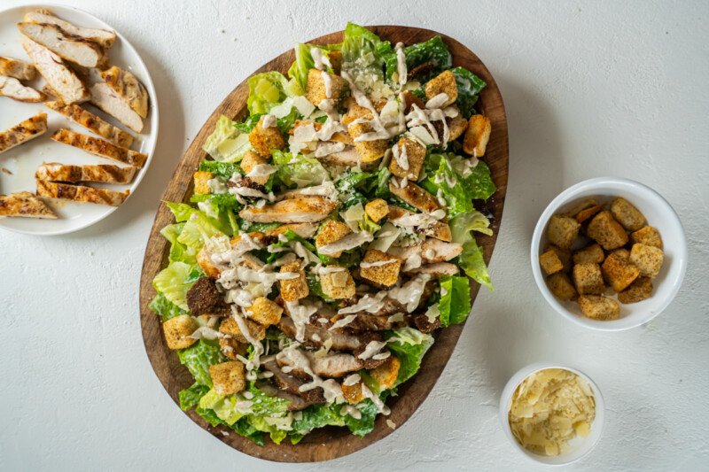 chicken caesar salad in a wooden serving bowl.