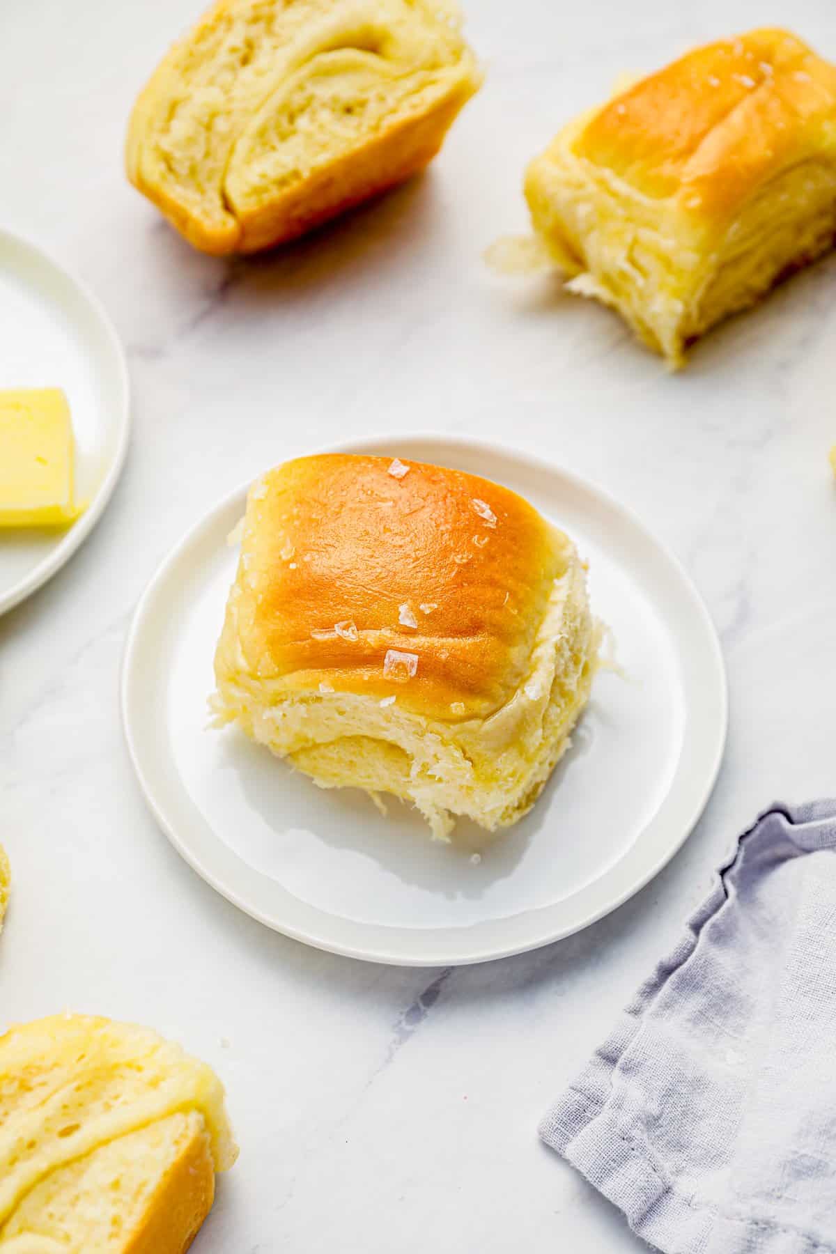 a parker house roll on a white plate.