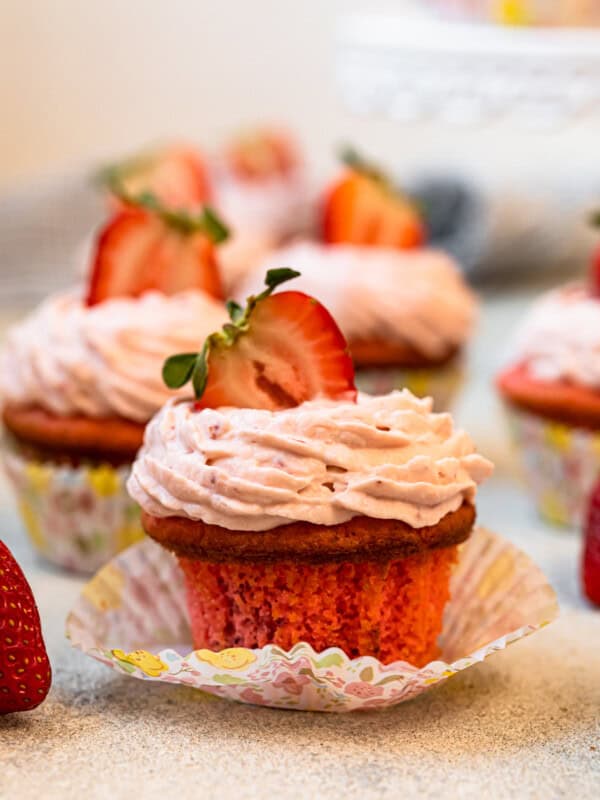 unwrapped strawberry cupcake on a colorful cupcake wrapper.