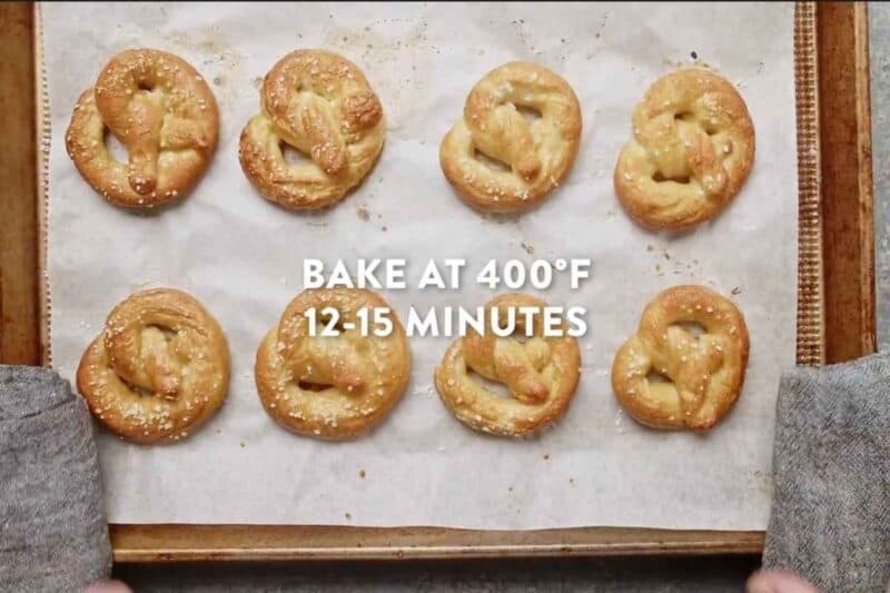 8 baked pretzels in a baking sheet lined with parchment paper