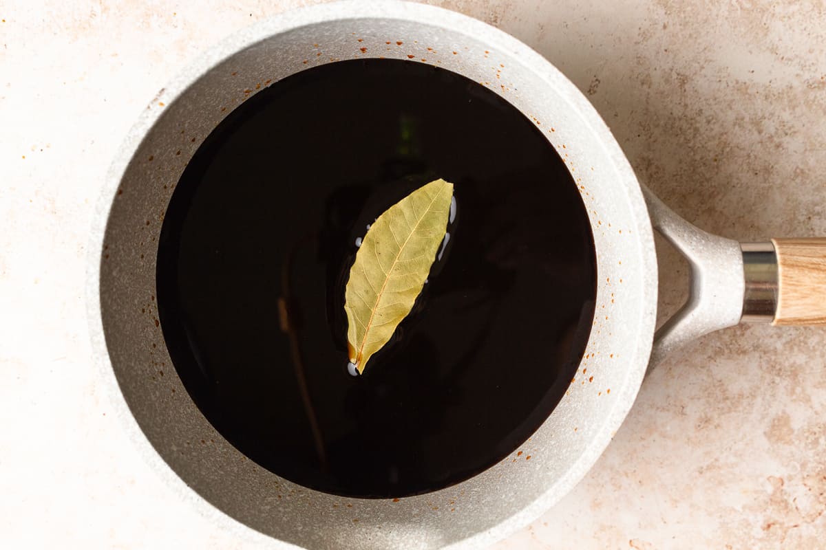 Bay leaf floating in a saucepan with balsamic.