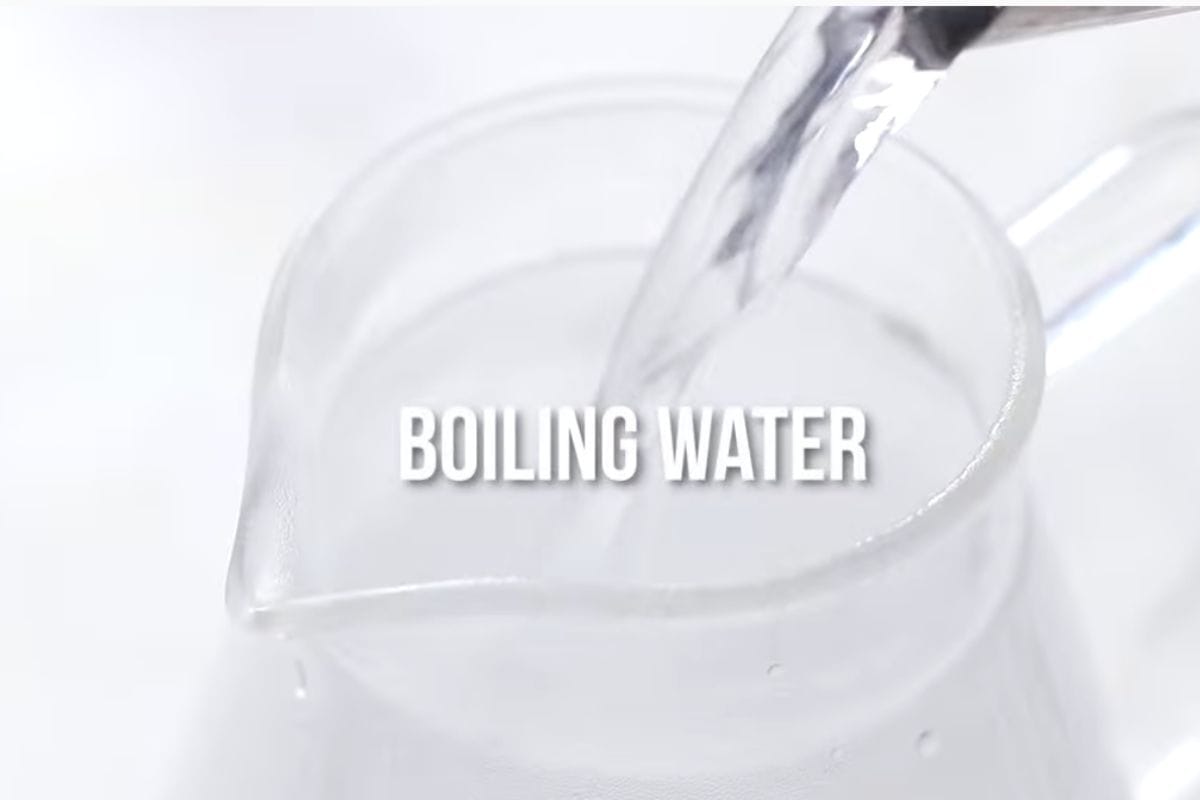 pouring boiling water in a glass pitcher.