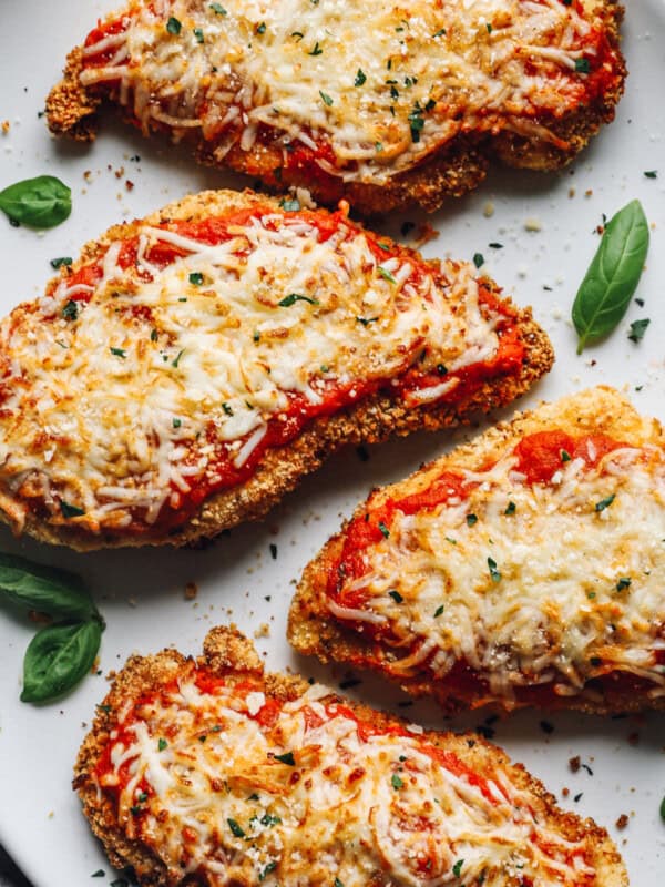 close up of 4 pieces of air fryer chicken parmesan on a white serving platter.