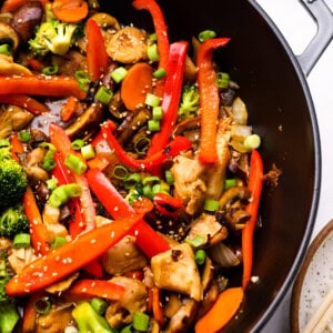 close up view of chicken stir fry in a cast iron wok.