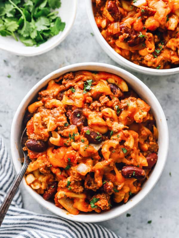 overhead view of crockpot chili mac in white bowls with a fork.