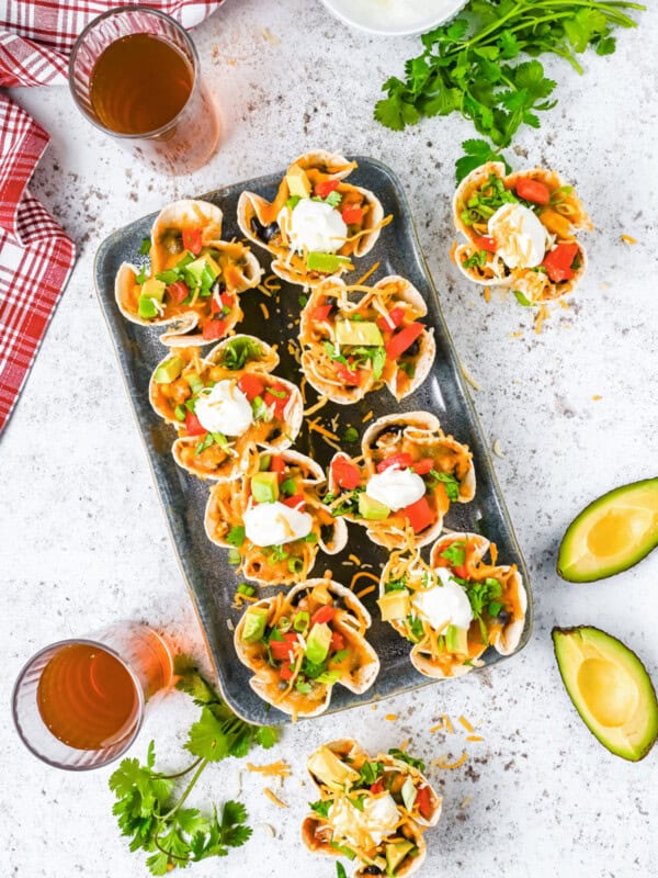 overhead view of 8 enchilada cups on a metal serving tray.