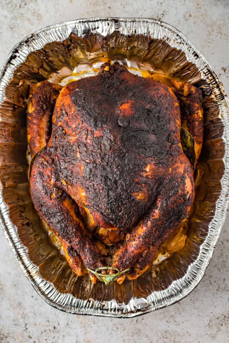 overhead view of dry brined turkey in an aluminum roasting pan.