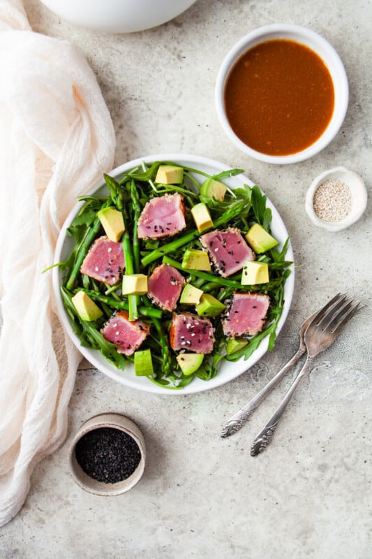 Ahi Tuna sliced up and served on a plate of asparagus