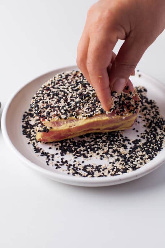 coating Ahi Tuna steak with black and white sesame seeds