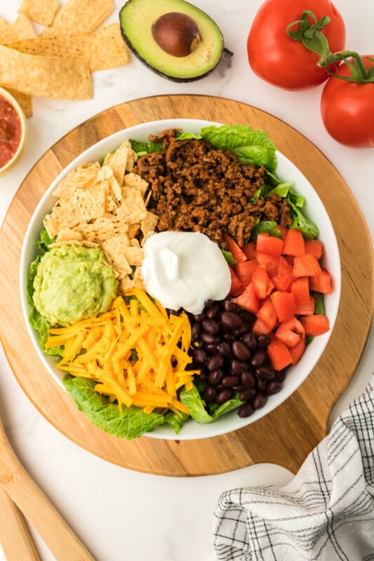 taco sakad on a tabletop, with ingredients arranged around the bowl