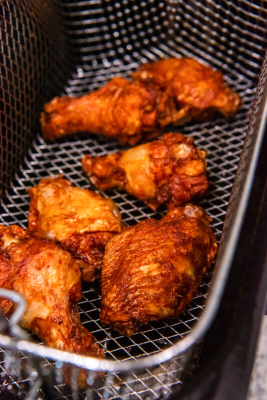 trashed wings in a deep fryer basket.