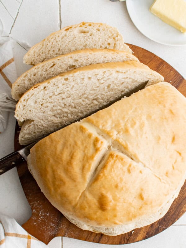 cutting a loaf of skillet bread into slices