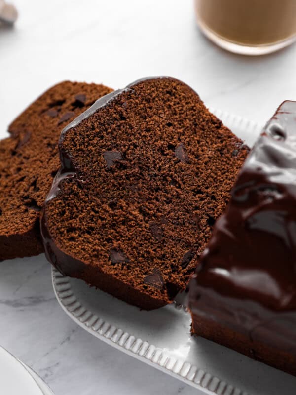 close up of sliced chocolate pound cake on a white serving plate.