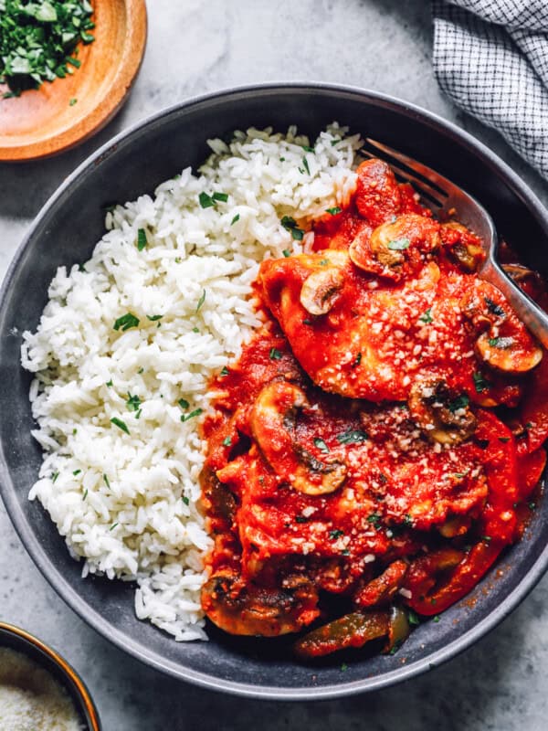 overhead view of crockpot chicken cacciatore with rice in a black bowl.