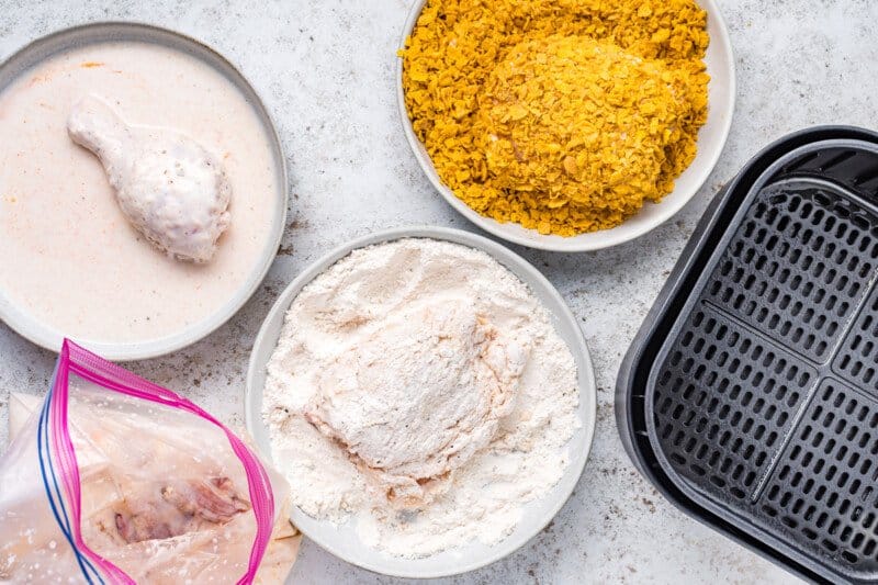 overhead view of chicken pieces dredged in flour and cornflakes.