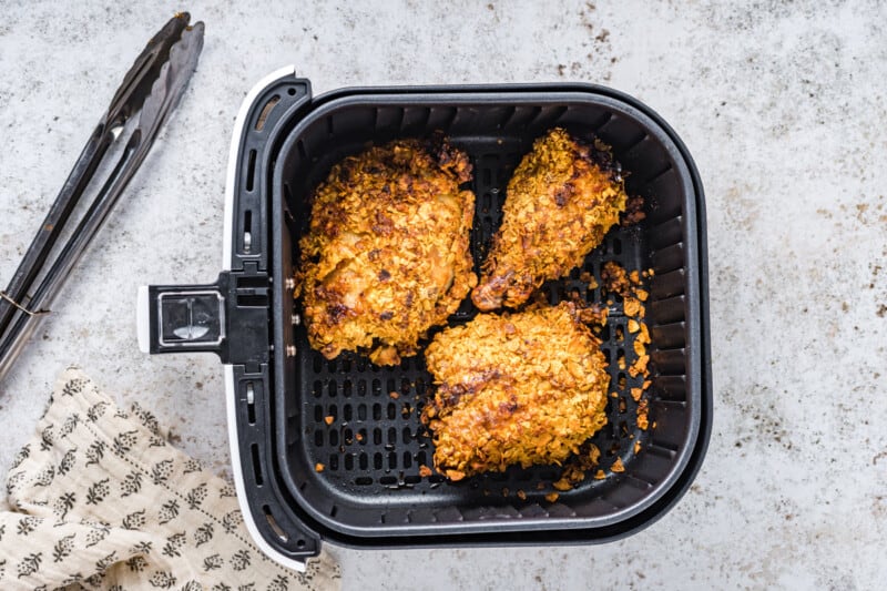 overhead view of air fryer fried chicken in an air fryer basket.