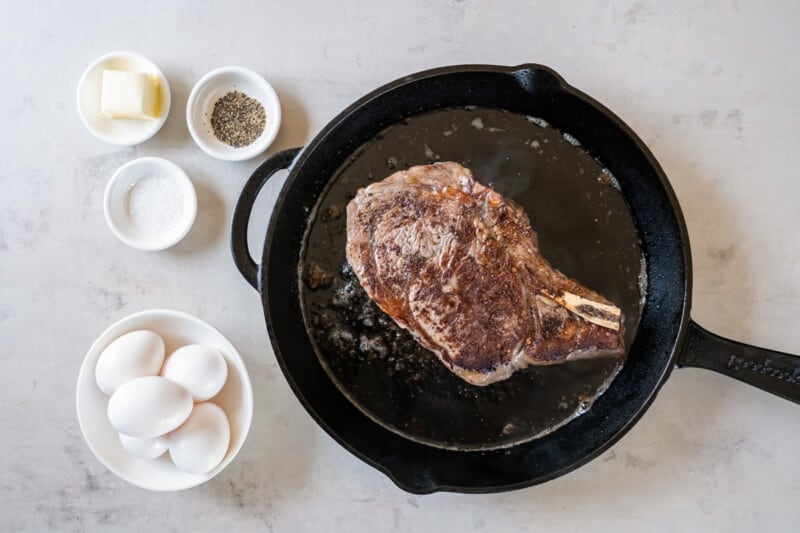 overhead view of cooked steak in a cast iron skillet.