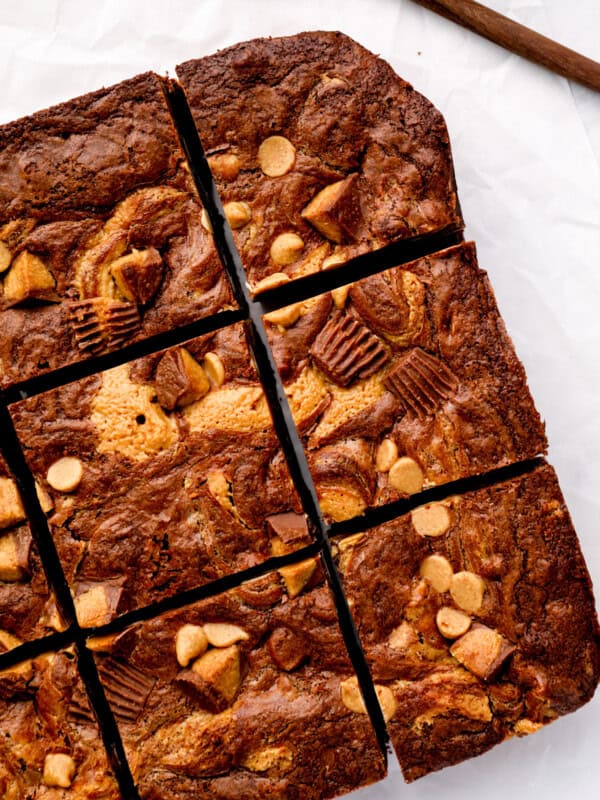 overhead view of cut peanut butter brownies on a white cutting board.