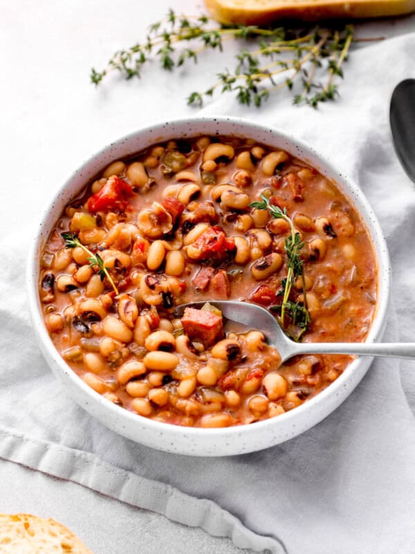 crockpot black eyed peas in a white bowl with a spoon.