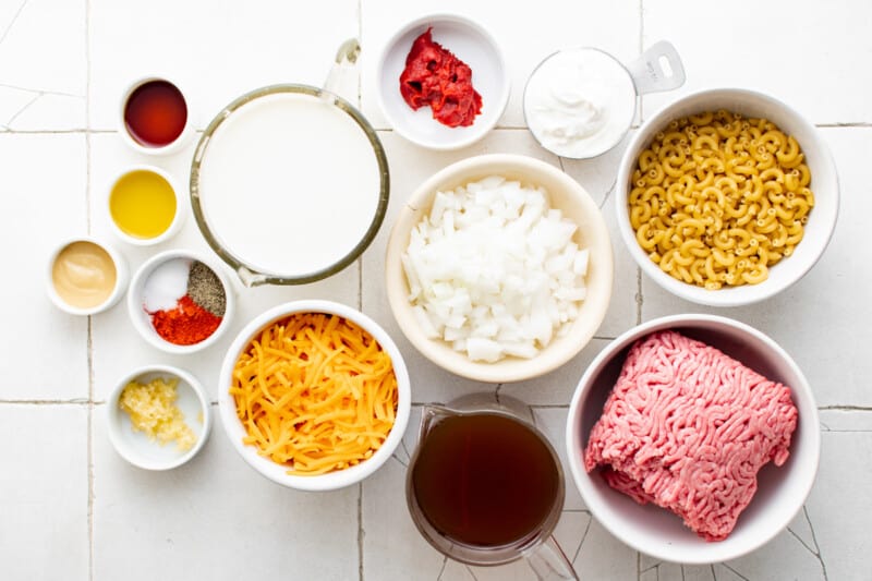 overhead view of ingredients for hamburger helper in white bowls.