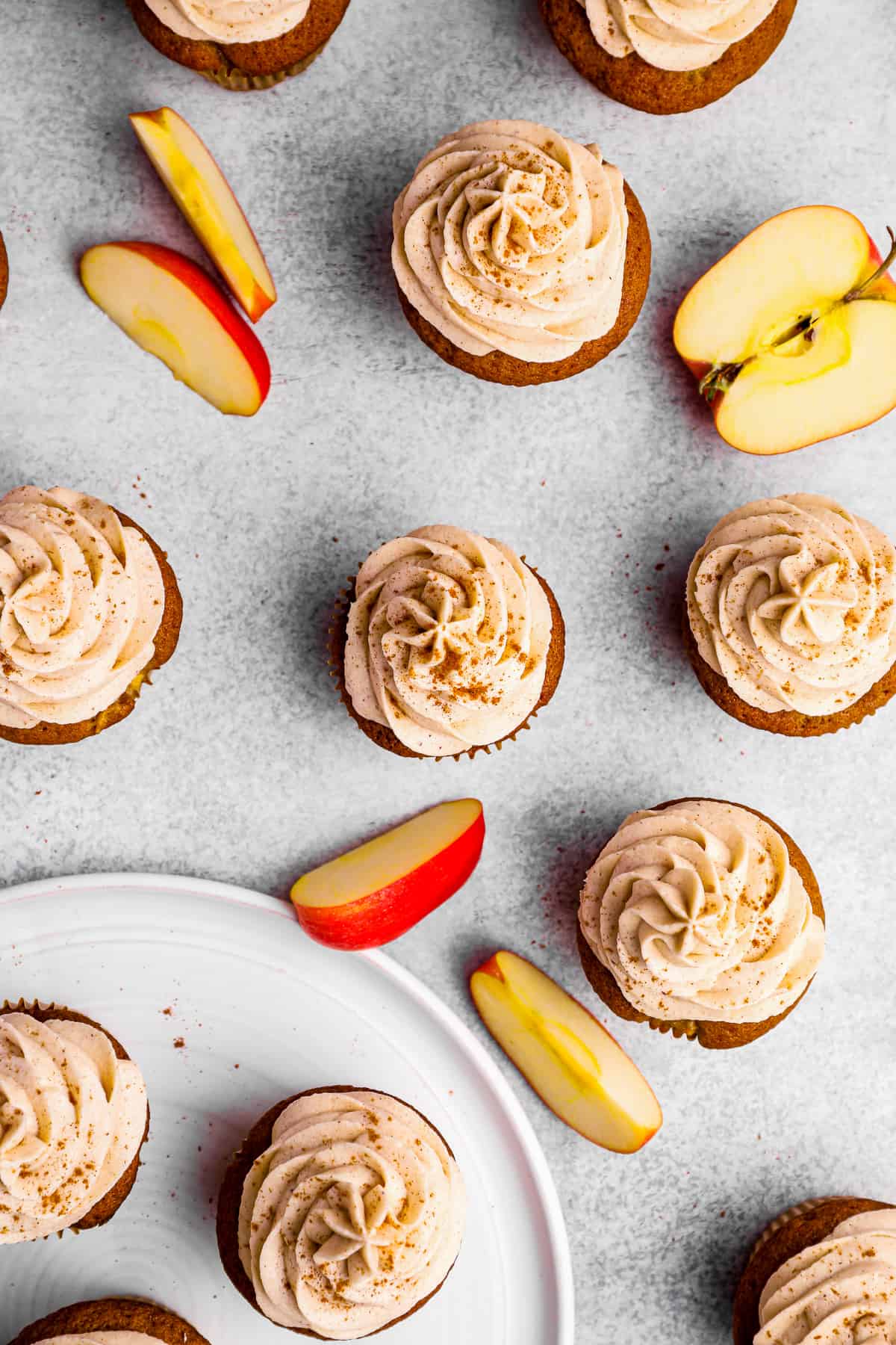 overhead view of apple cupcakes arranged on a table top with apple slices