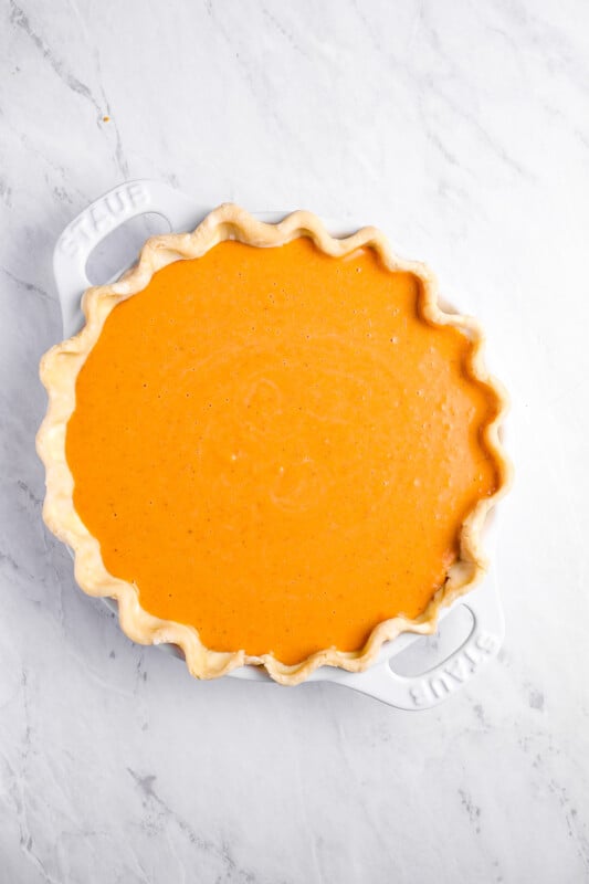 overhead view of sweet potato pie filling poured into crust in a pie pan.