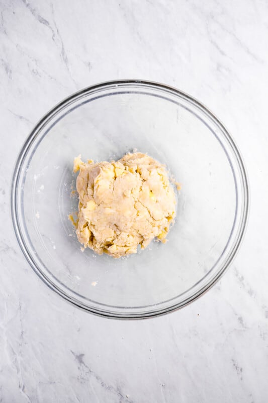 overhead view of sweet potato pie dough in a glass bowl.