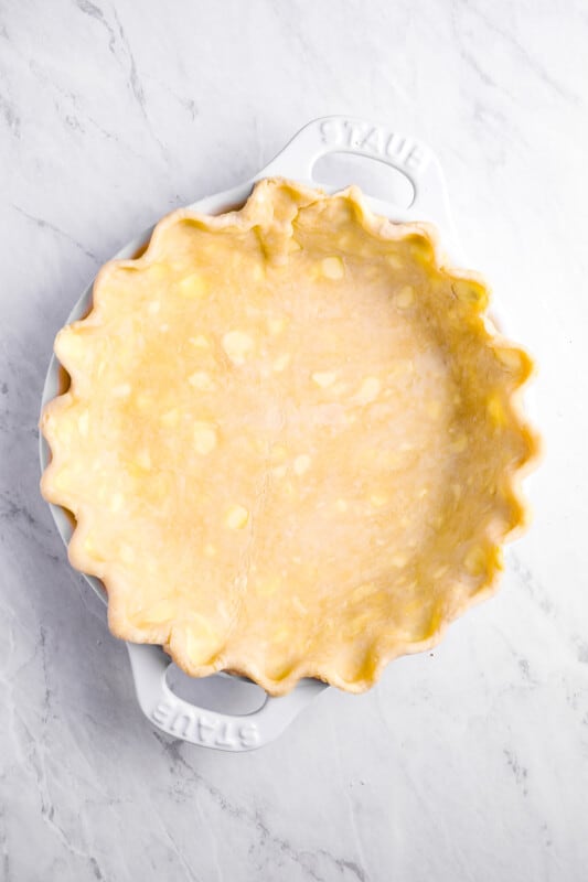 overhead view of sweet potato pie crust pressed into a pie pan and crimped.