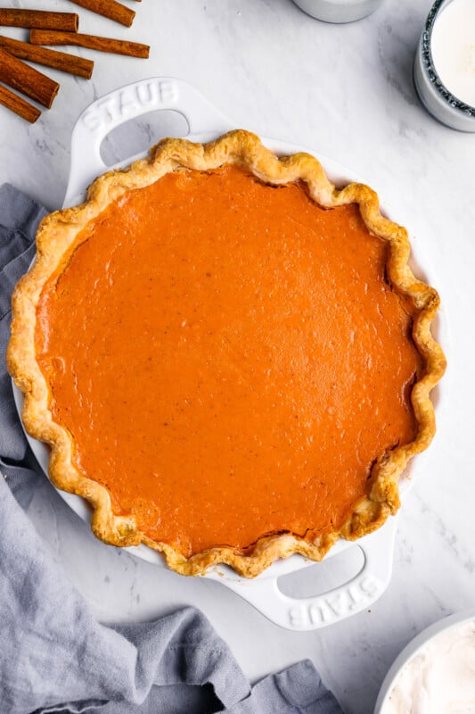 overhead view of sweet potato pie in a white pie pan with handles.