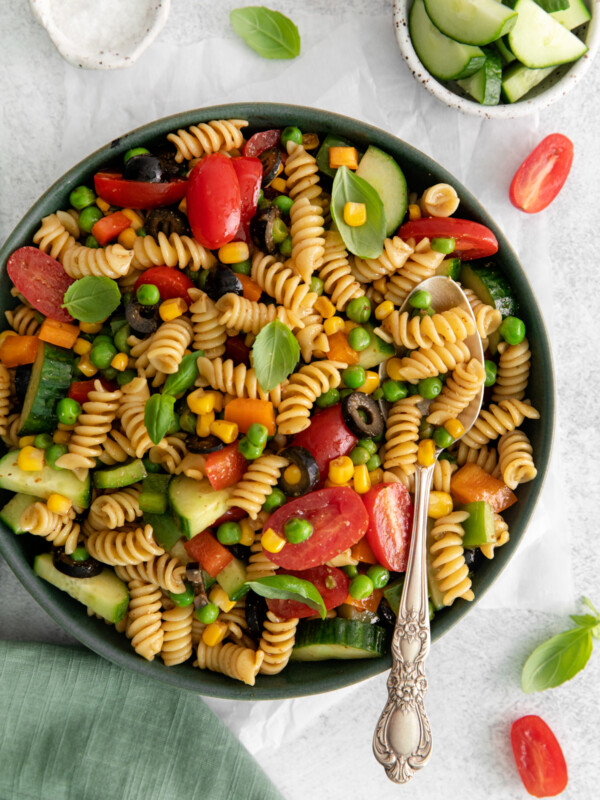 overhead view of veggie pasta salad in a gray bowl with a spoon.