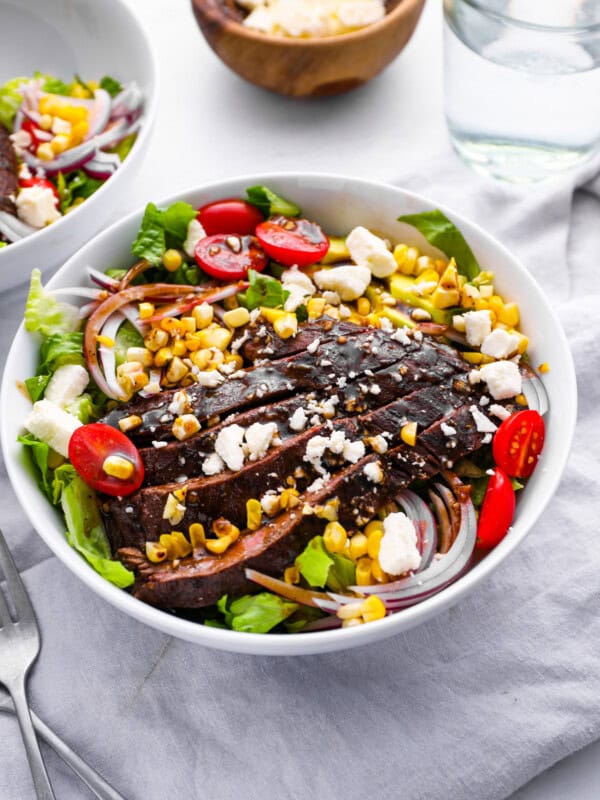 steak salad in a white bowl.