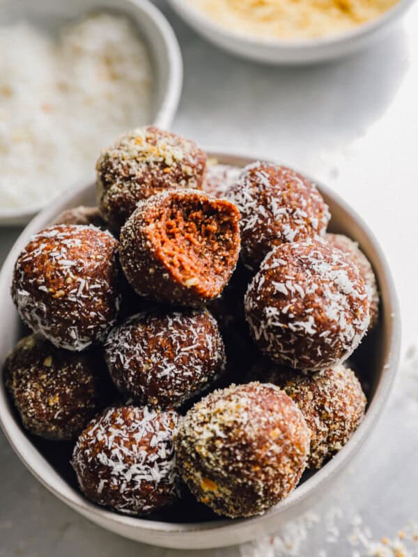 a bitten rum ball on top of a bowl of rum balls.