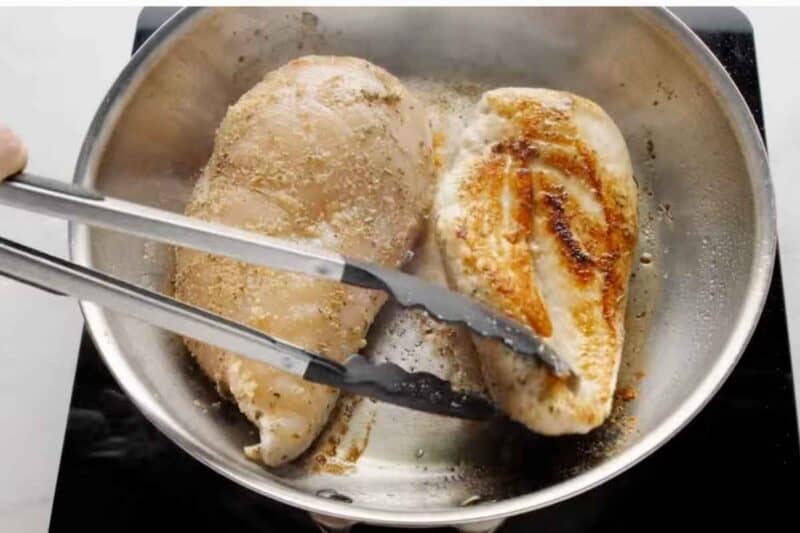 pan searing chicken breasts. Flipping over after 2 mins.