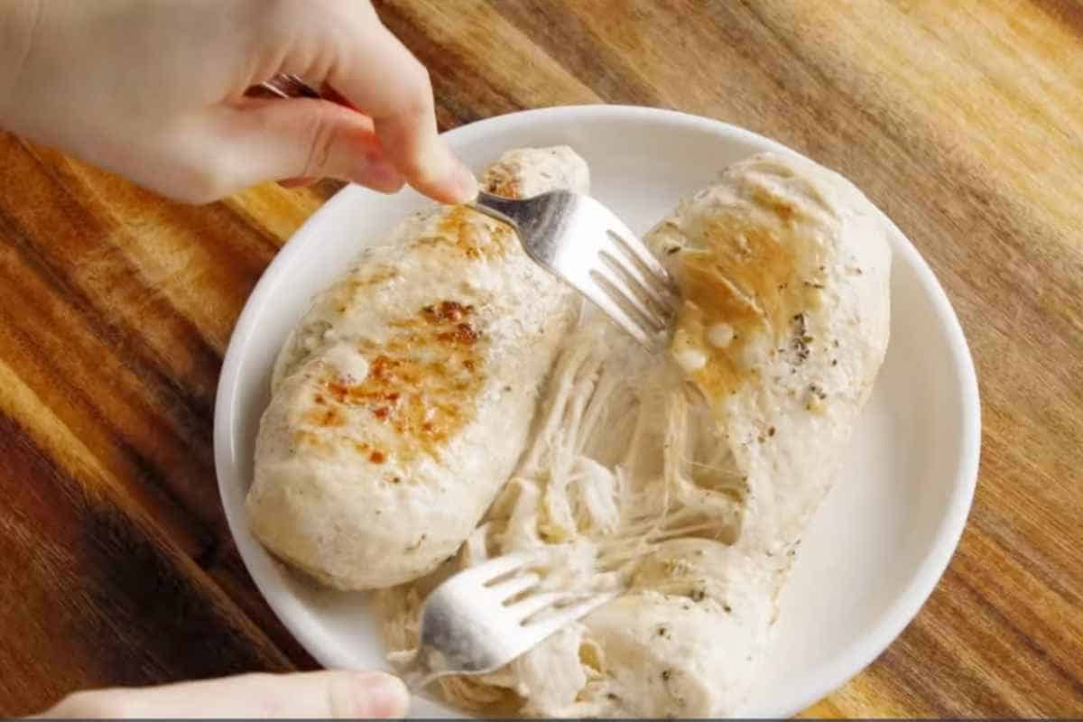 shredding the chicken with the help of fork.