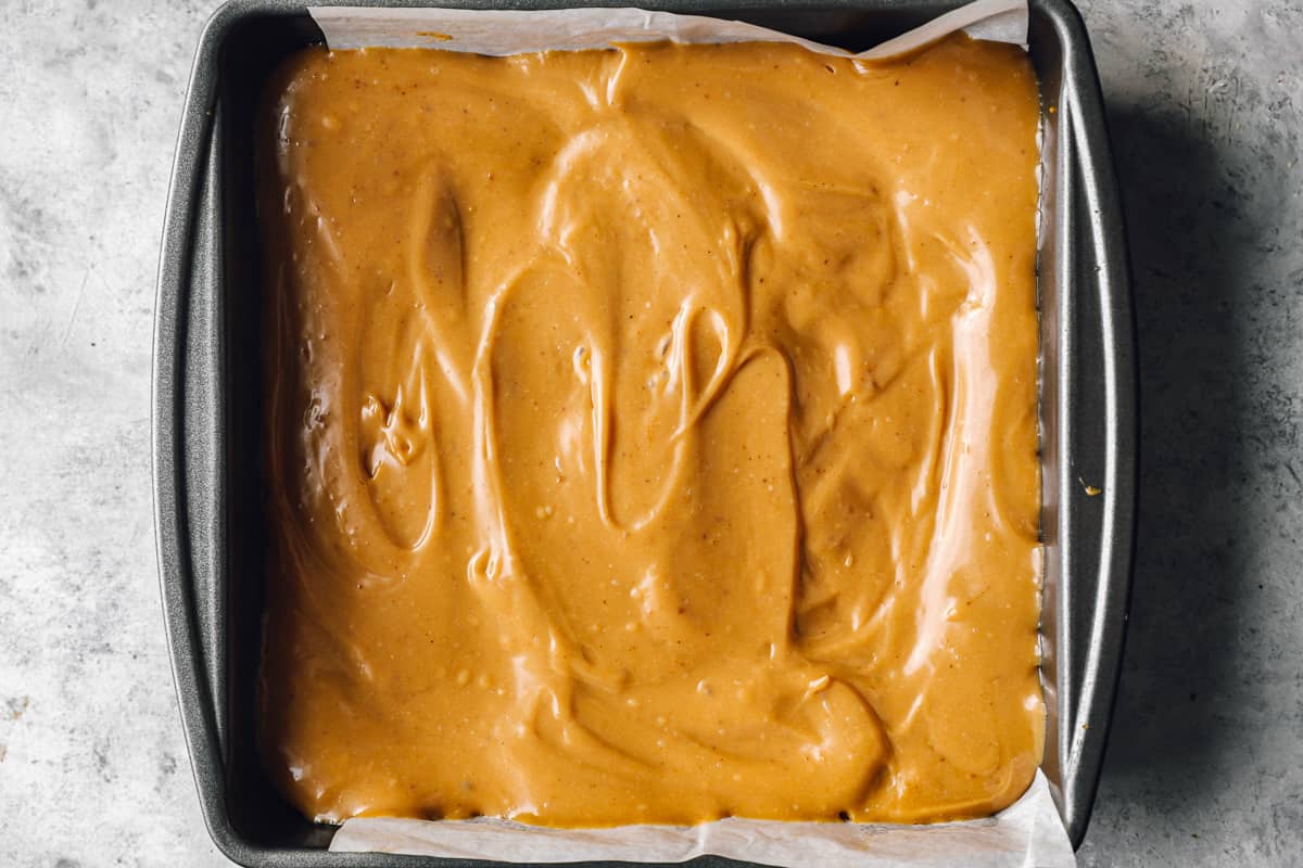 caramel spread over shortbread in a square baking pan.