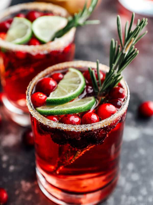 2 glasses of jingle juice garnished with lime slices and rosemary.