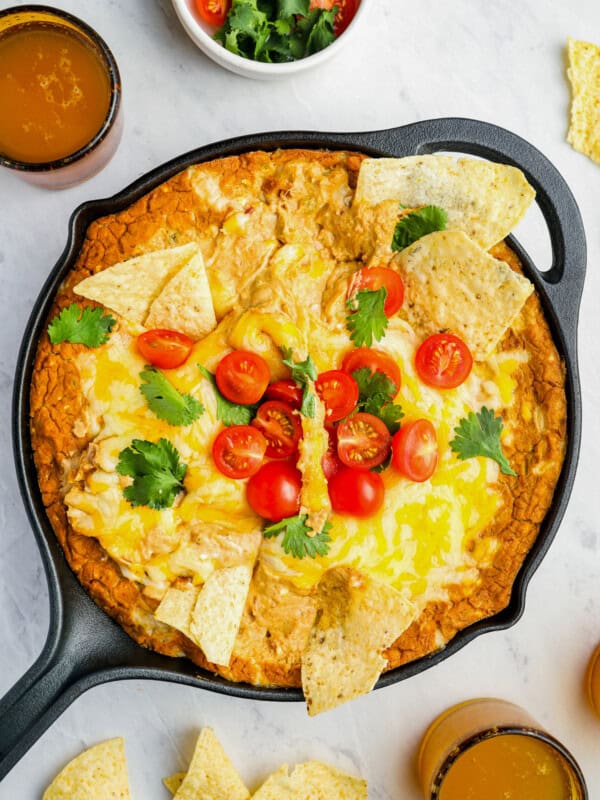 overhead view of cheesy bean dip in a cast iron skillet with the handle pointing to the left.