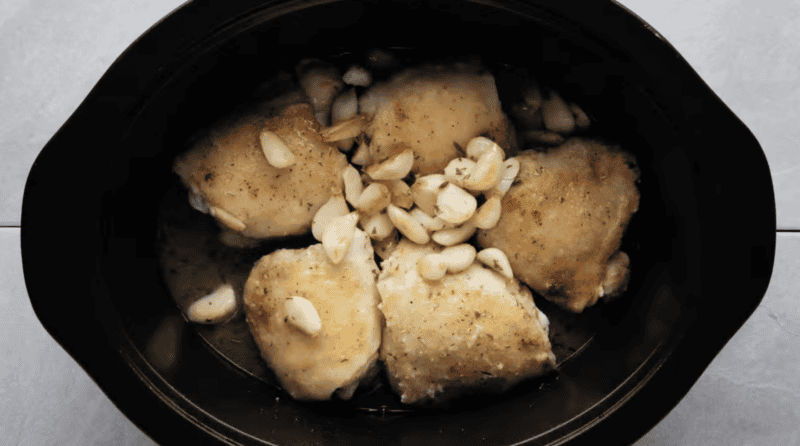 seared chicken and garlic in a crockpot.