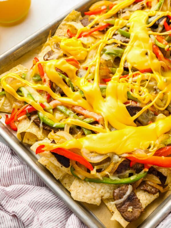 partial view of philly cheesesteak nachos on a baking sheet.